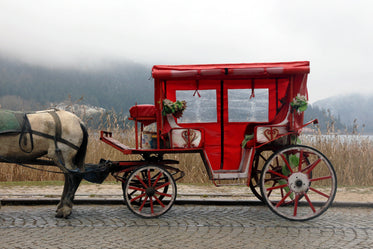 a red and white carriage with a horse attached to it