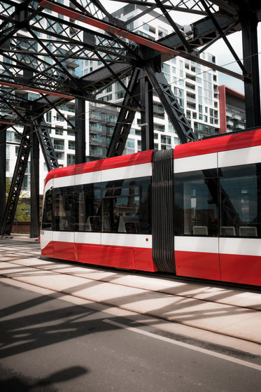 a red and white vehicle under a metal structure