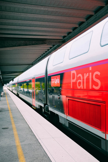 a red paris-bound train at a platform