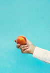 a ripe peach held in the hand