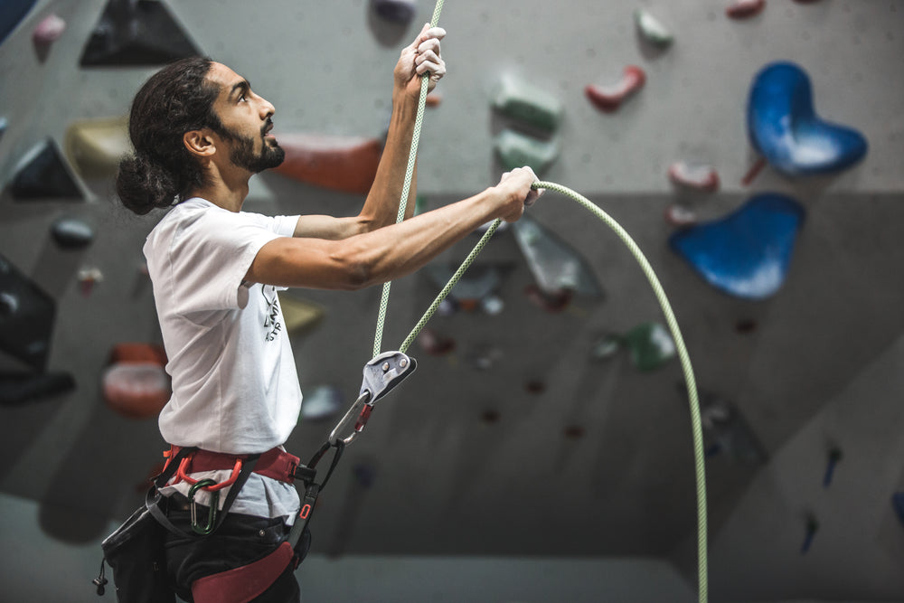 a rock climber belaying a climbing rope