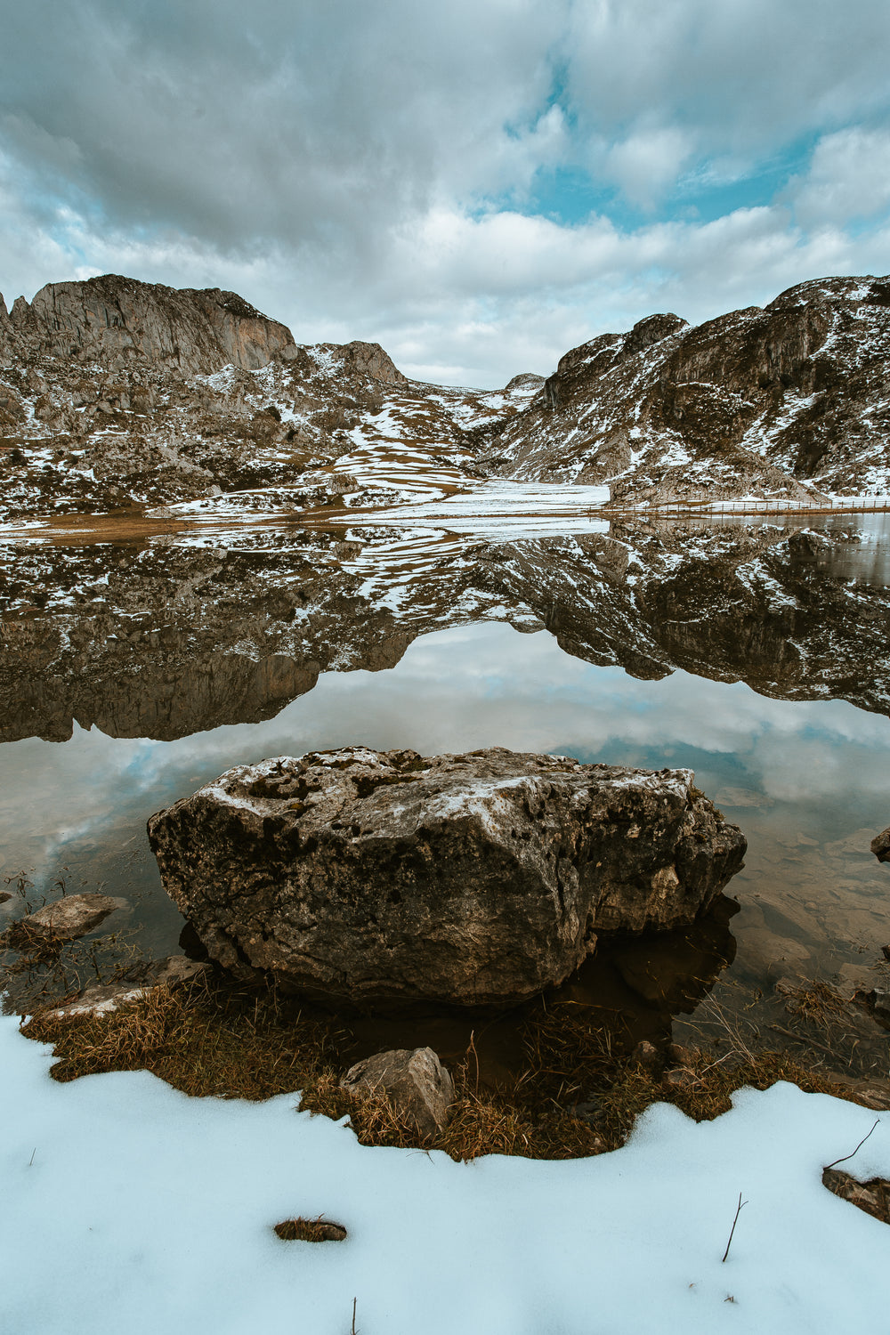 a rock stands in the middle of the lake