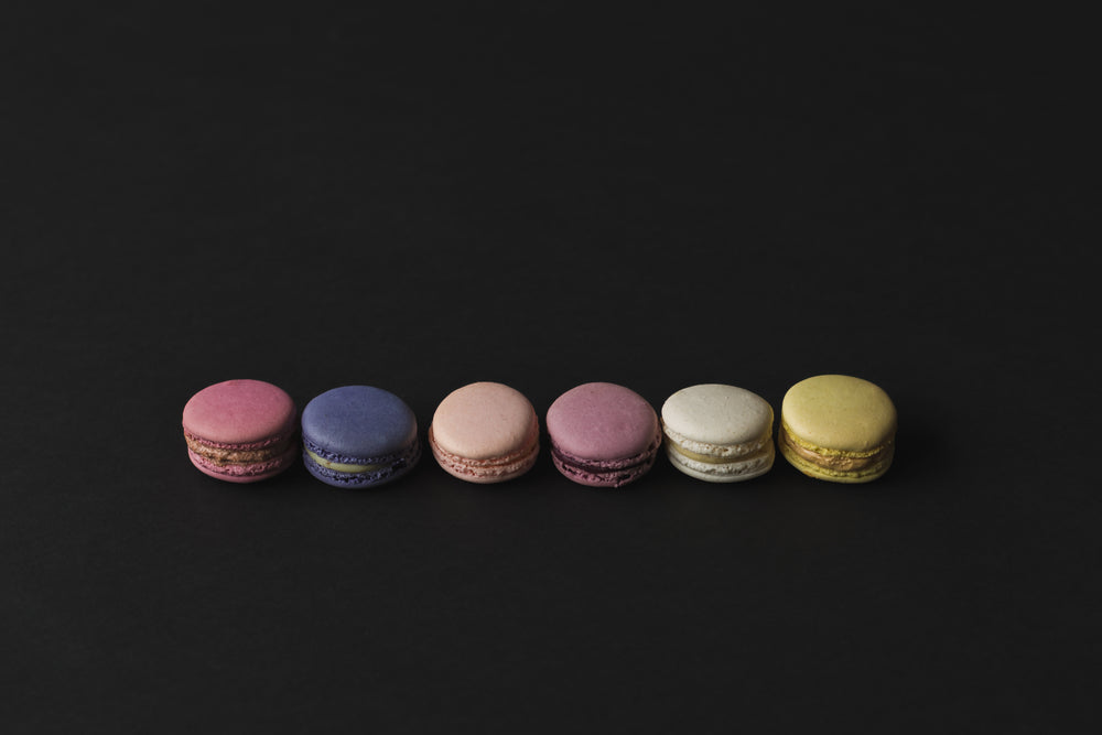 a row of colored macarons in shadows