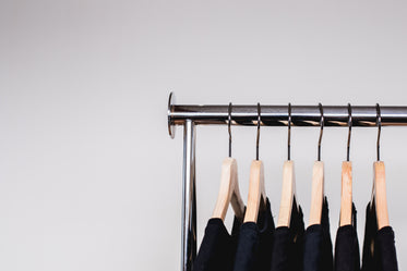 a row of dark shirts on a rack