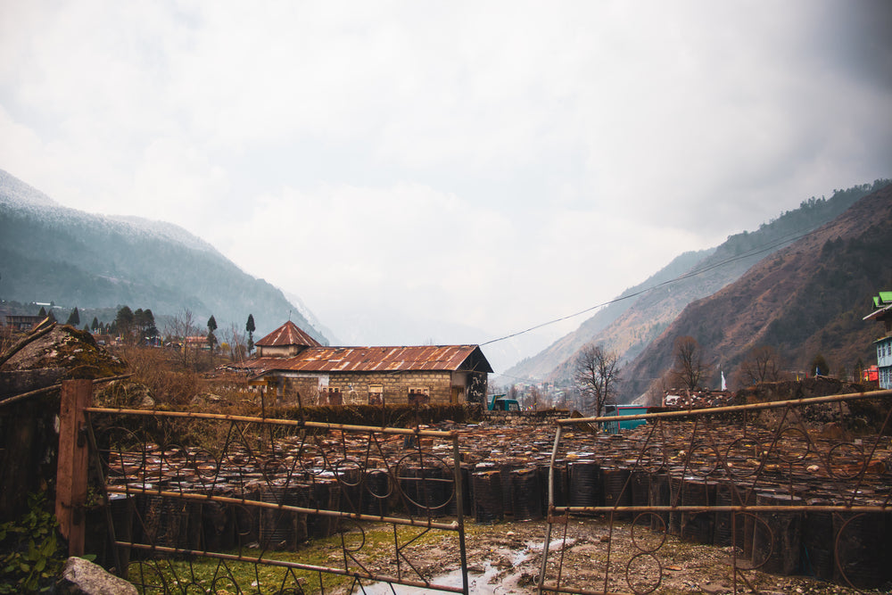 a rustic building sitting between two hills