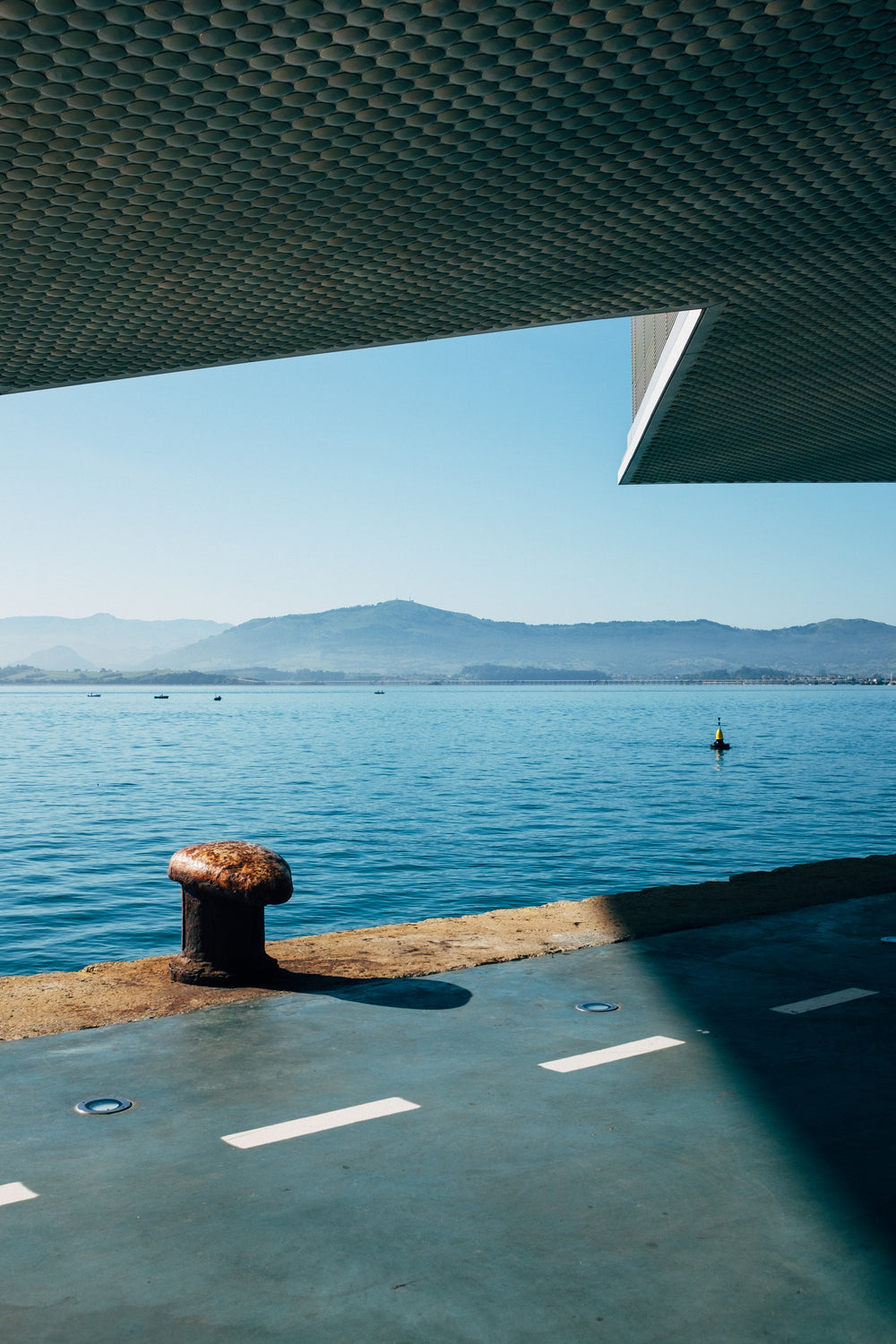 a rusty boat at a dock in the sunlight