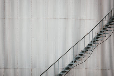 a rusty iron staircase ascends an iron building