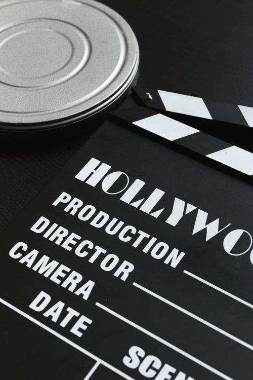 a silver film reel canister and a movie clapper board