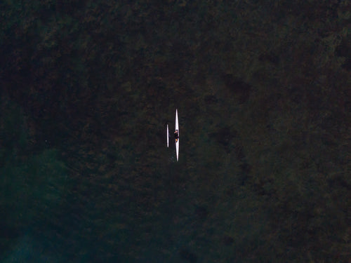 a single rower gliding through clear water