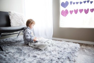 a small child reads near a window