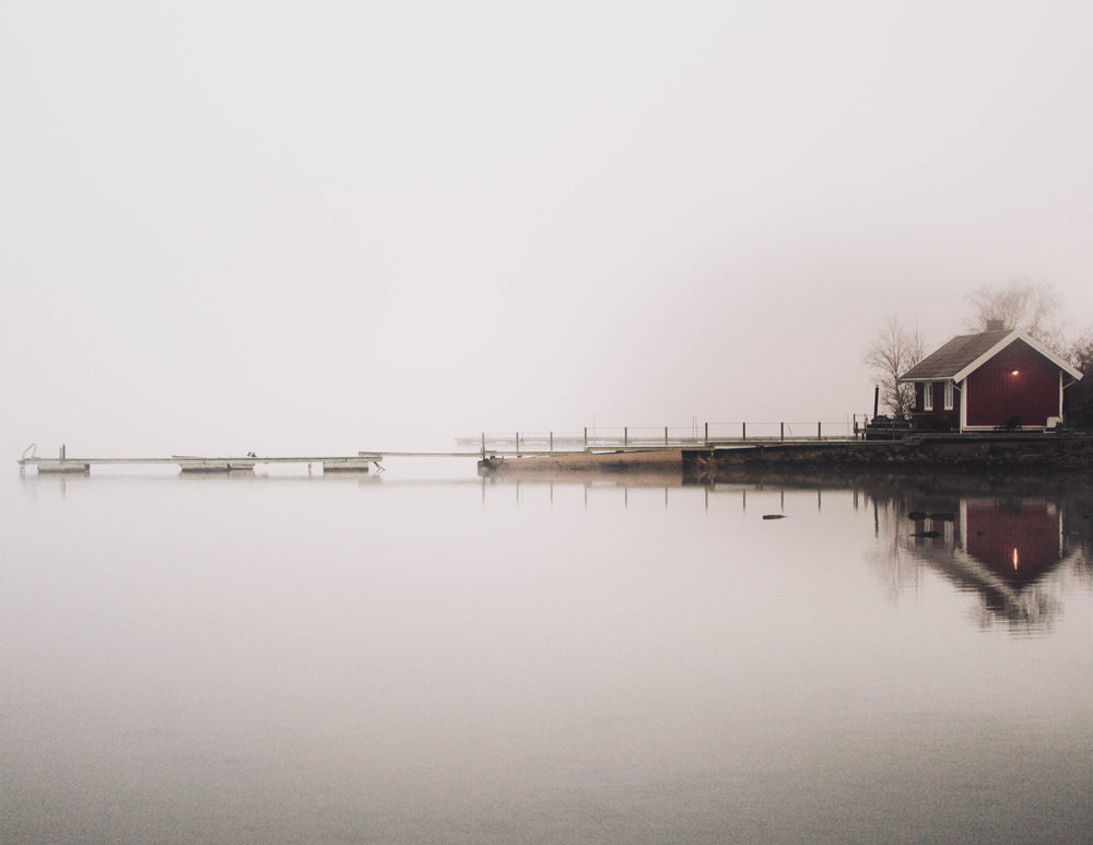 a small house overlooking a misty lake