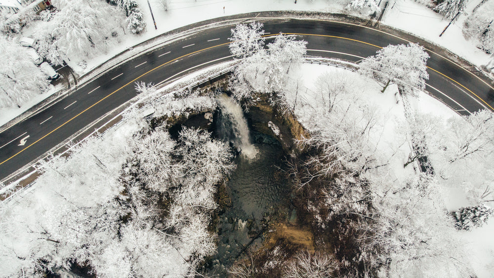 a small waterfall framed by a highway