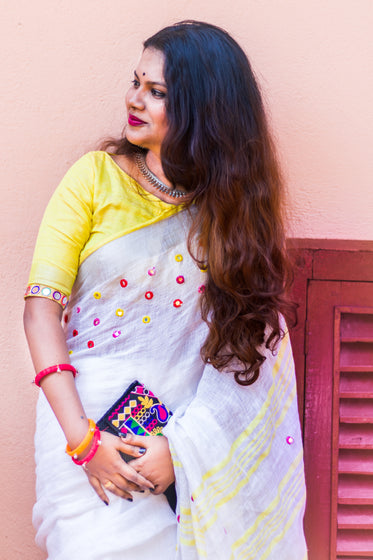 a smiling woman holding a colorful purse