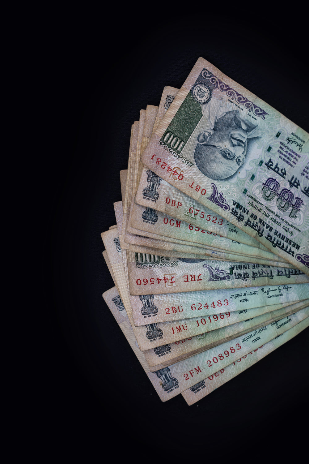 a stack of currency on a black background