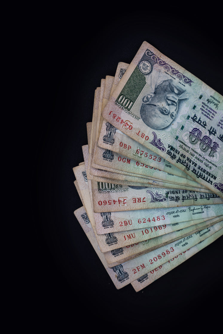 A Stack Of Currency On A Black Background