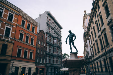 a statue of a man holding a ladle in a town square
