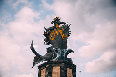 a statue of poseidon riding a large fish on a wave