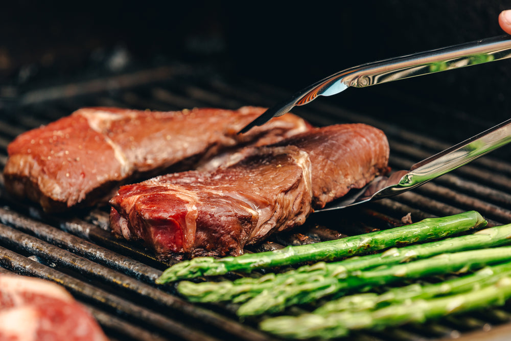 a steak on a grill about to be flipped