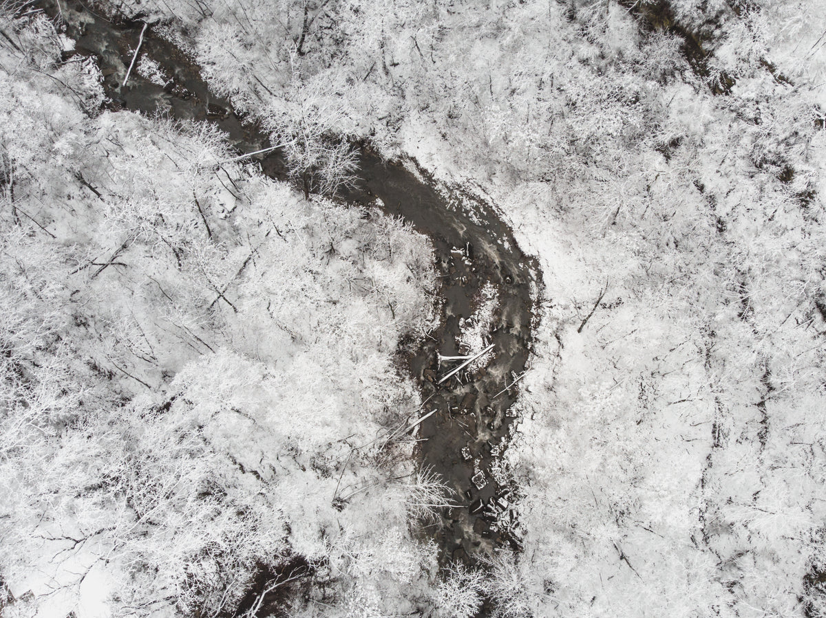 a stream flows through the snowy landscape