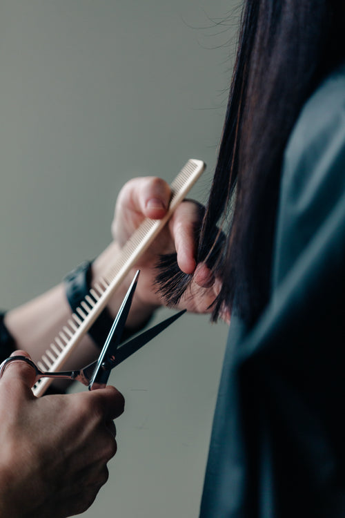 a stylist measures before cutting