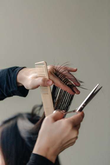 a stylist pulls a woman's hair up