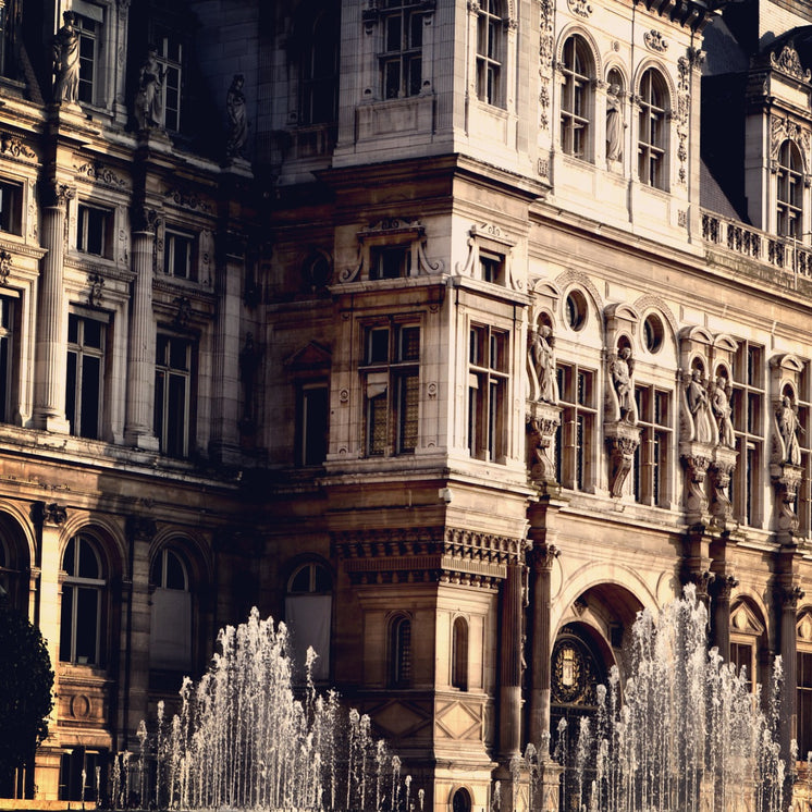A Sun-Kissed Baroque Building OverLooking Water Fountains
