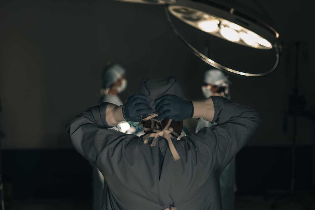 a surgeon ties his head scrub