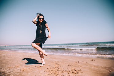 a tattooed woman enjoys the sun on the beach