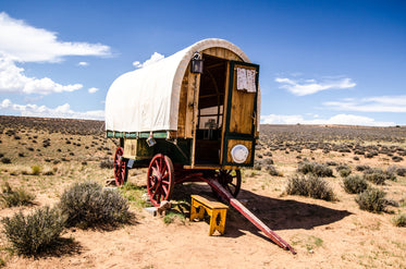 a traditional caravan rests under blue skies in the plains