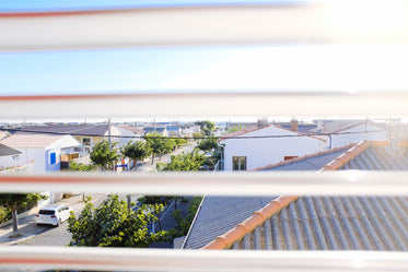 a view of rooftops through window blinds