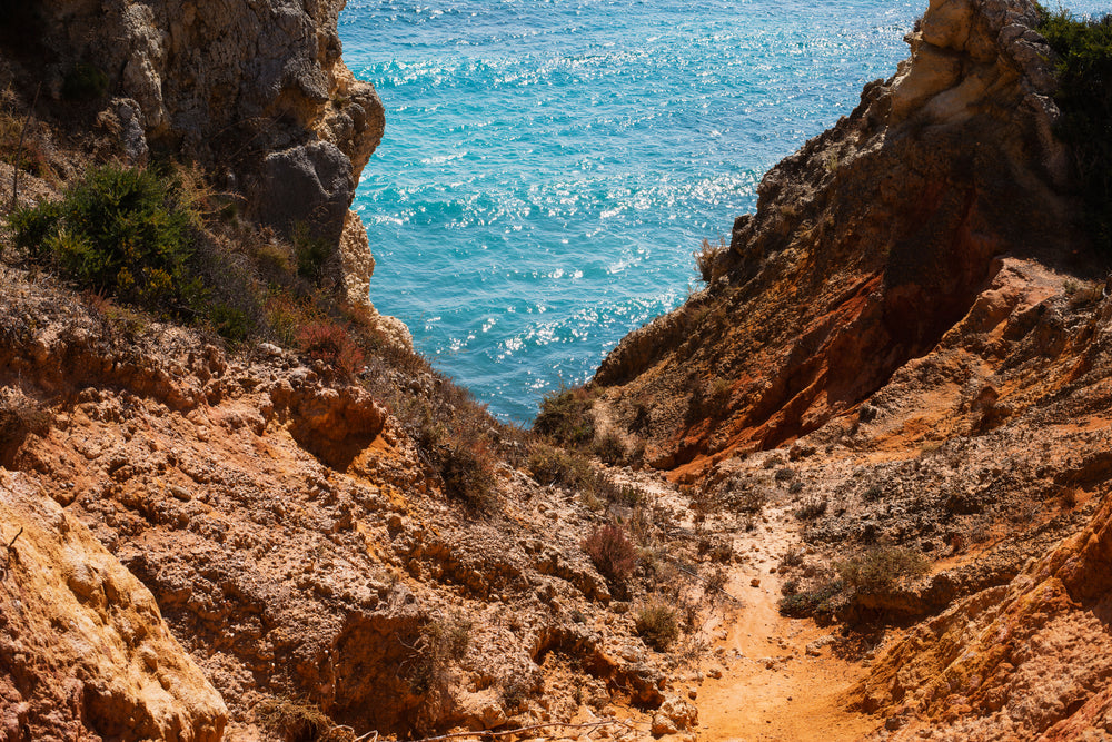 a view of the sea from a rocky cliff side