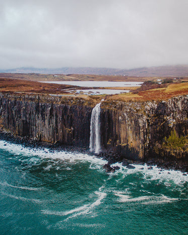 a waterfall cascades down the side of a large cliff