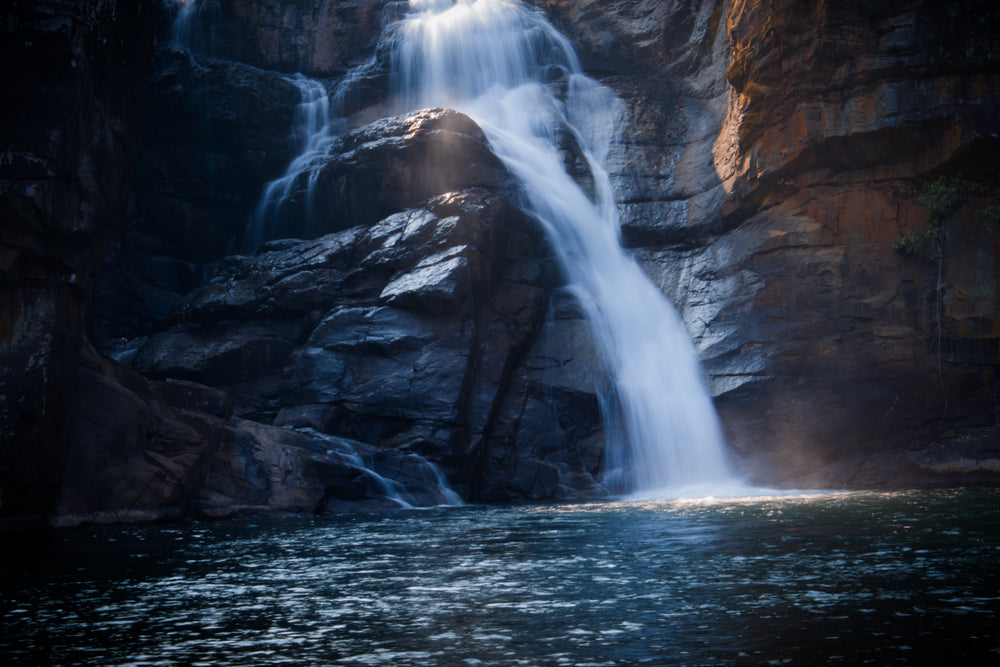 a waterfall over rocks into the lake below