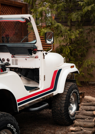 a white convertible jeep with a red and blue stripe