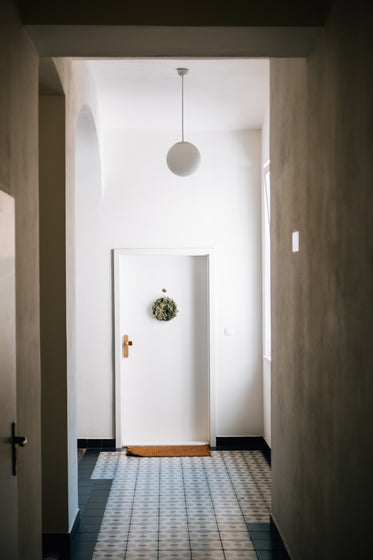 a white door at the end of a long white hallway