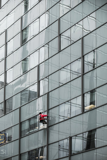 a window washer dangles from a skyscraper