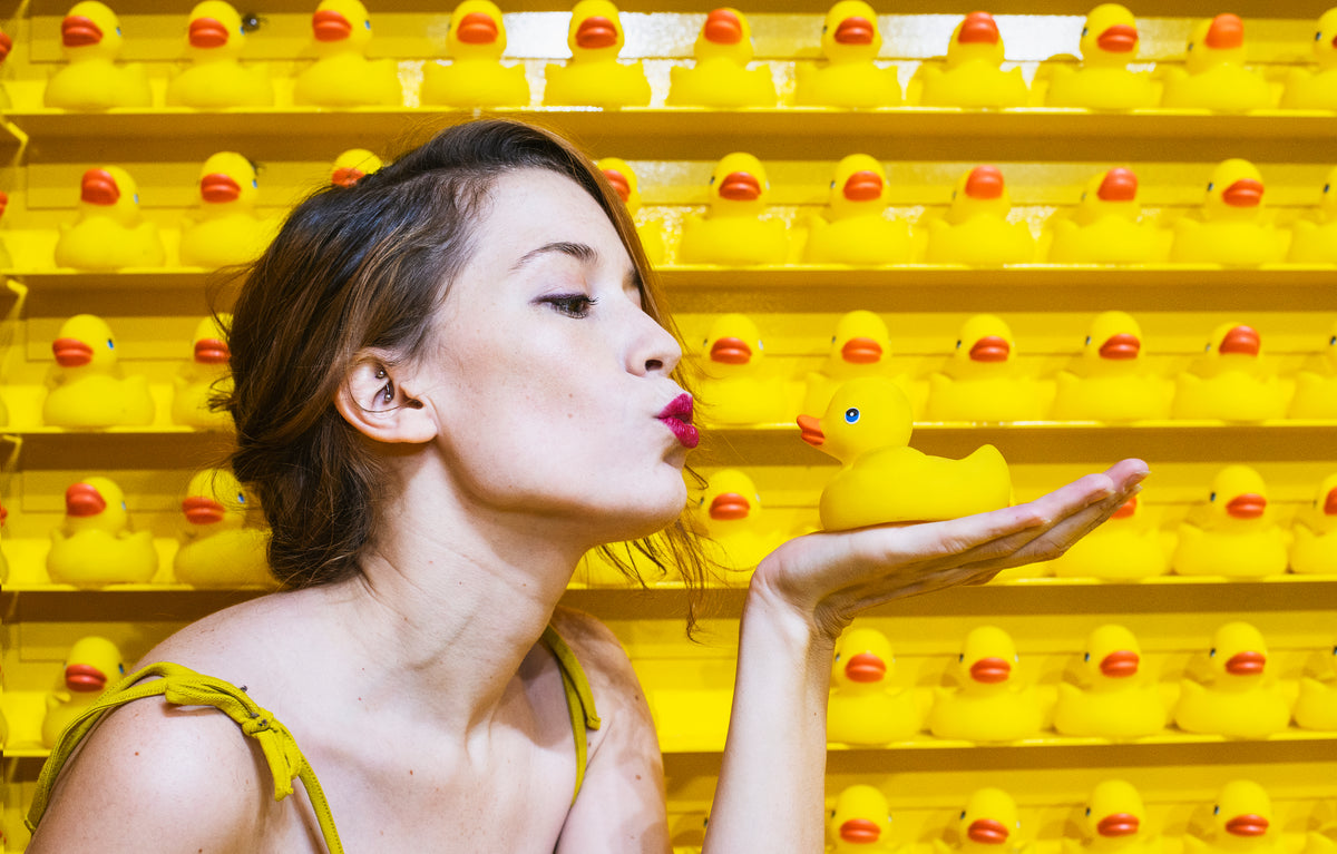 a woman blows rubber duck kisses