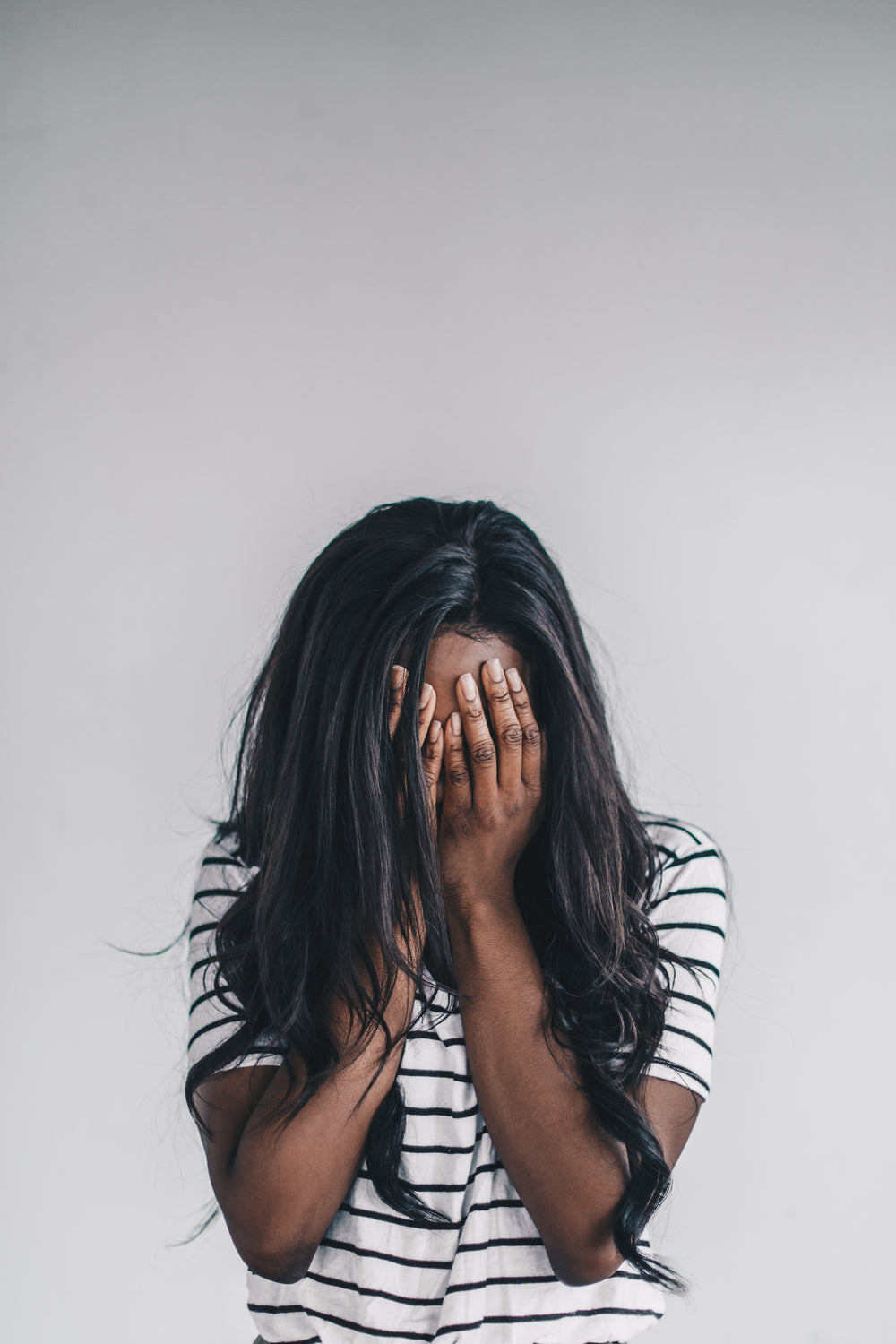 a woman buries her face in her hands