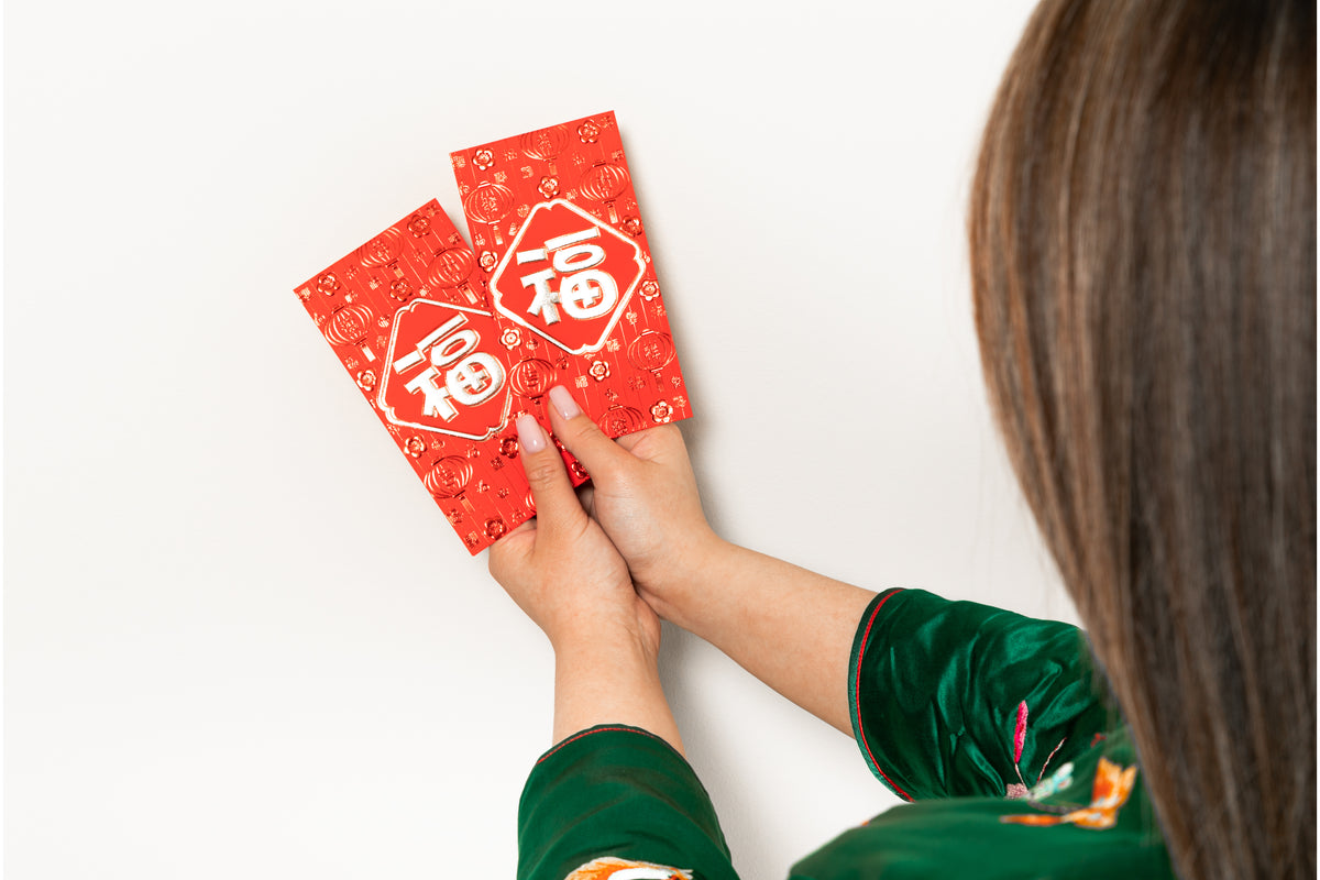 a woman holds two red envelopes