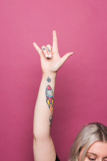 a woman holds up the i love you sign