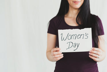 a woman holds 'women's day" sign