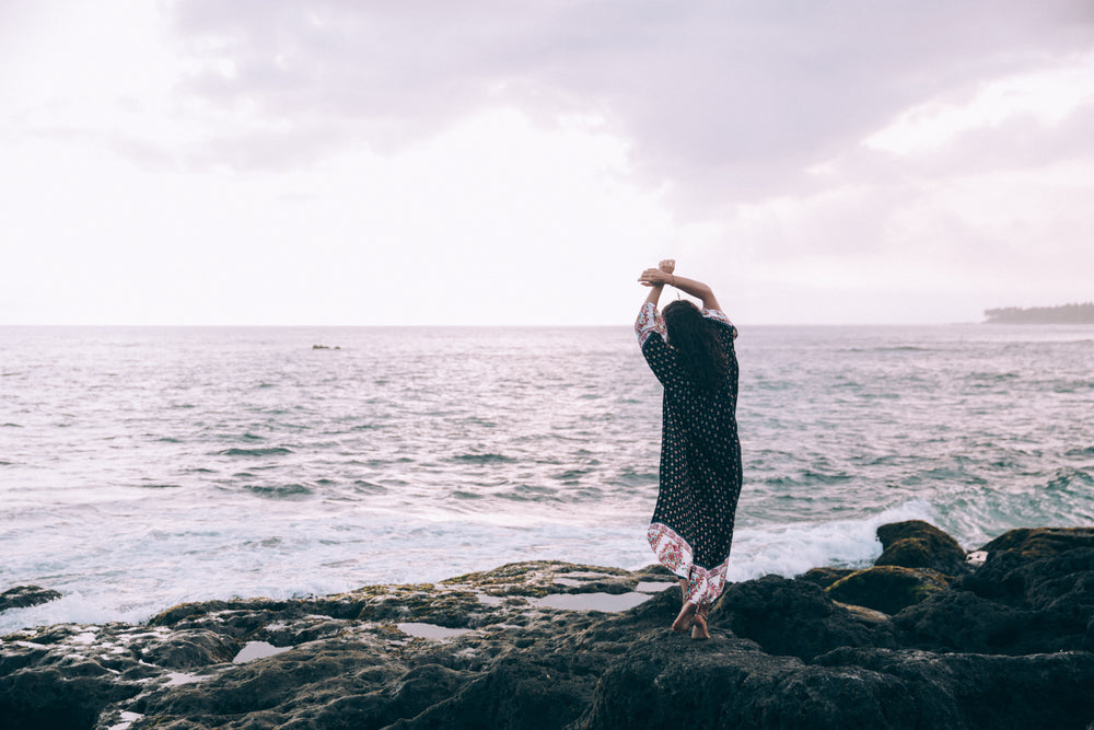 a woman in a beach robe poses on the beach