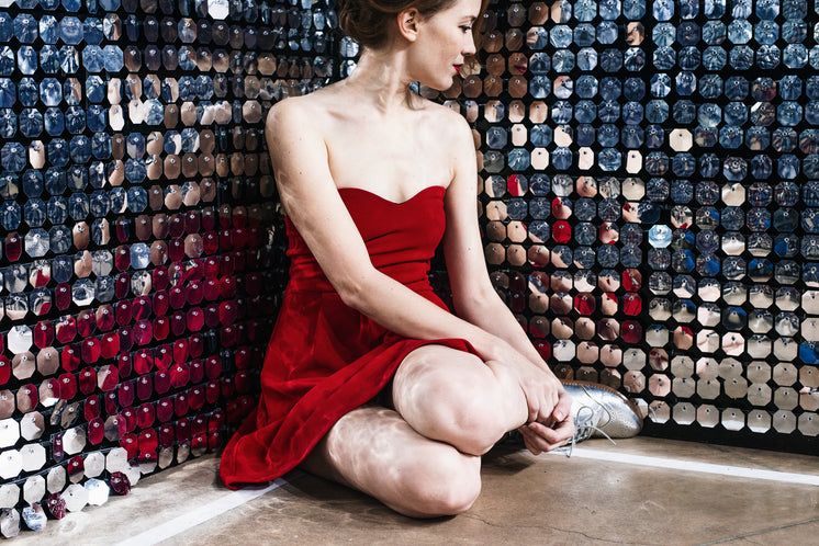a-woman-in-a-red-dress-sits-and-ponders-