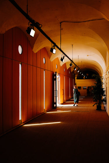 a woman in a summer dress walks through a corridor