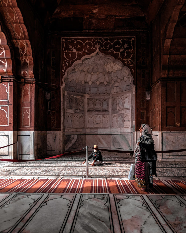 a-woman-in-red-walks-through-arched-hall.jpg?width=746&format=pjpg&exif=0&iptc=0