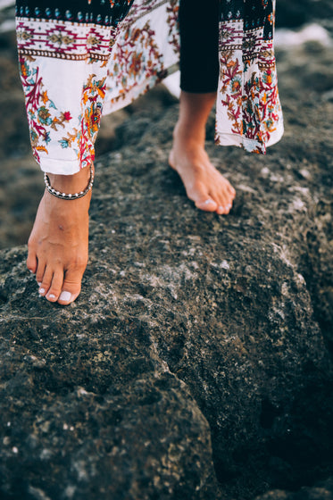 a woman leaves footprints in sand on sunset beach