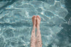 a woman points her toes while stretching her legs in pool