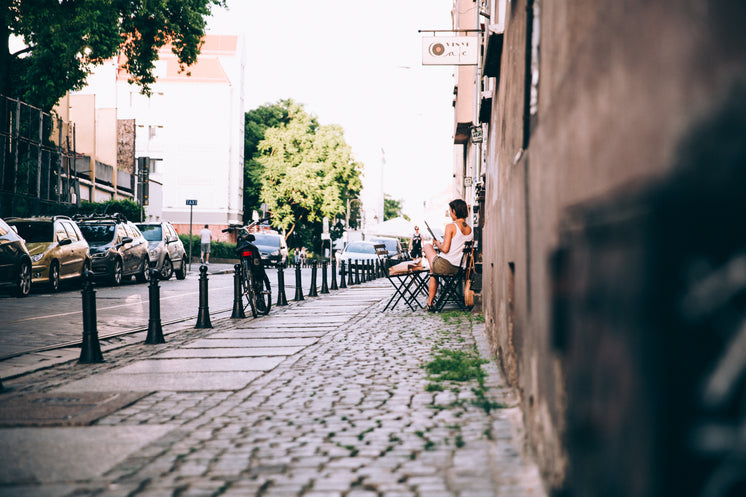 a-woman-reads-a-newspaper-outside-a-cafe