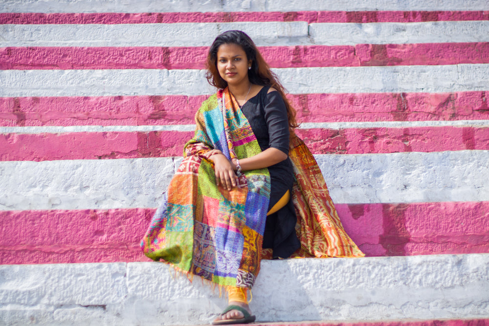 a woman sits upon a pink and white ledge