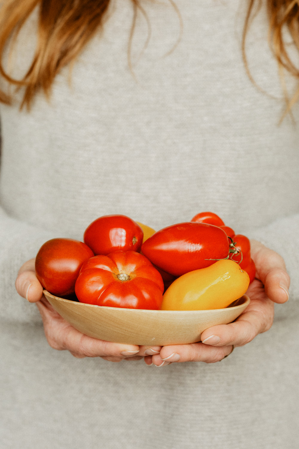 a woman with a bowl of tomatoes and peppers